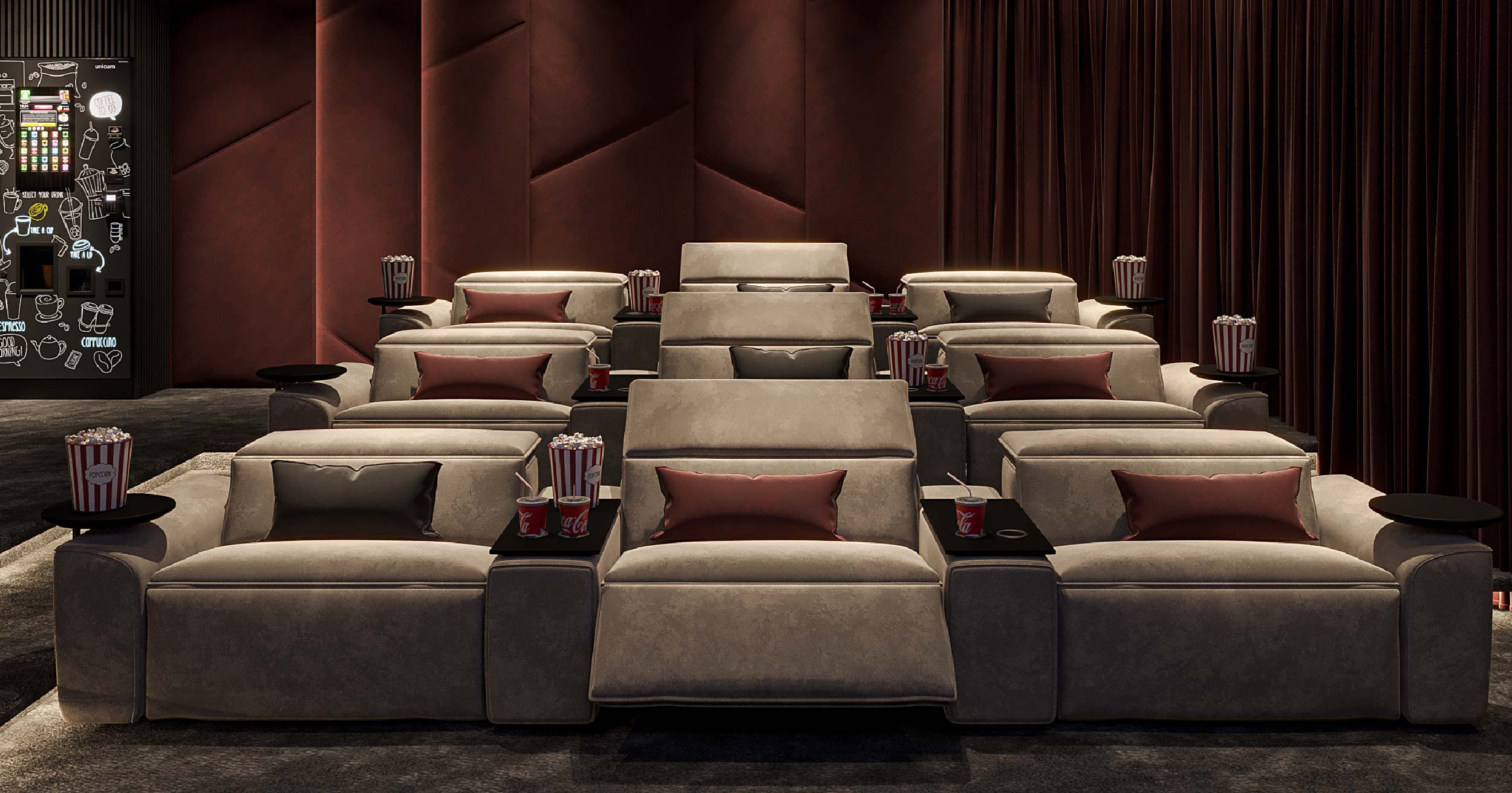 Luxor By Imtiaz A cozy movie theater seating area with plush sofas, popcorn buckets, and drink cups, set against rich red walls.
